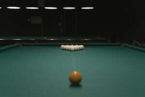 Pool table setup ready for break at a pool hall Akron Ohio with billiard balls arranged under soft lighting.