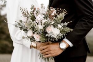 Bride and groom holding a rose bouquet at a bridal shower event space
