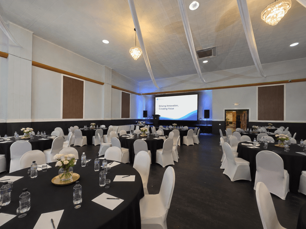 Corporate event setup at Royal Palace Akron with round tables, presentation screen, and meeting seating